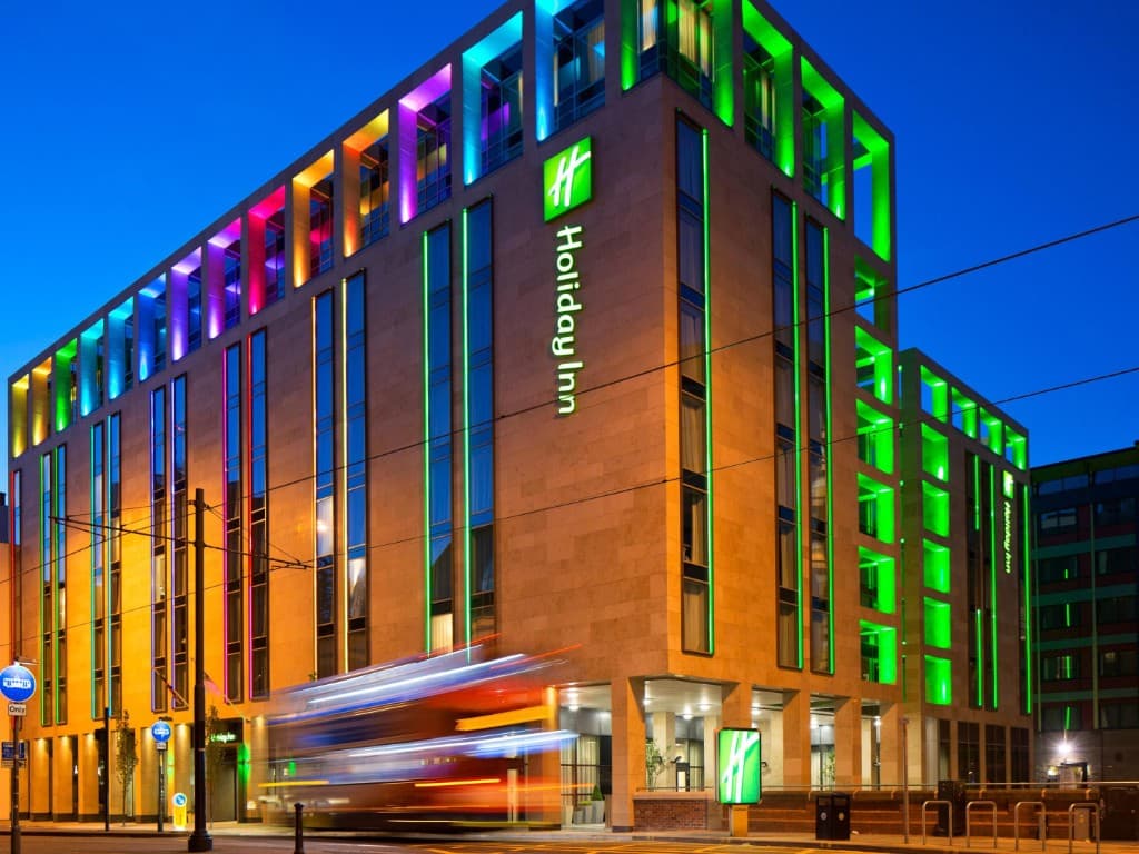 Holiday Inn Manchester City Centre at night, with coloured façade lighting